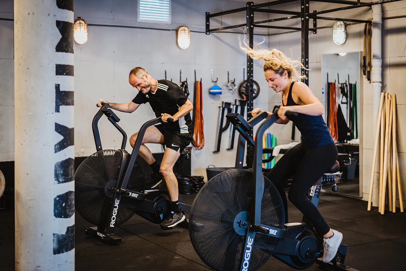Two members training side by side on air bikes at Bodytime